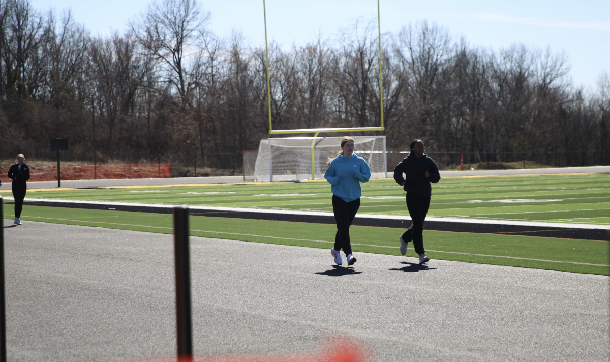 Track team runs the new track during tryouts as the new field is being used for the first time.