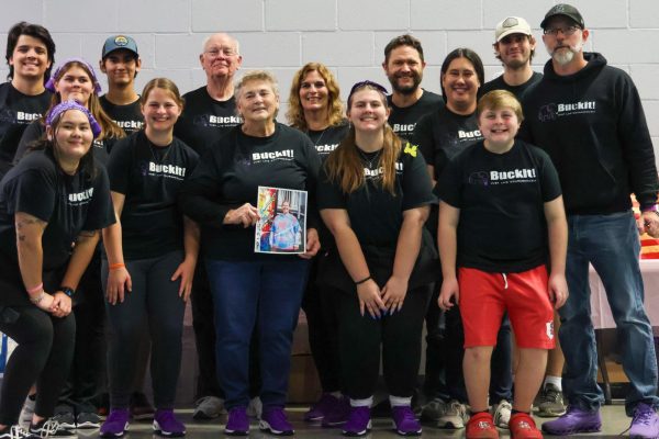 All of the Buckit! volunteers pose for a photo, holding a picture of their aunt, Jennifer Lynn Crum who passed away from cancer. They wear yellow butterflies, a symbol that reminds them of her spirit, as seeing the butterfly brings her memory to life in their hearts.
