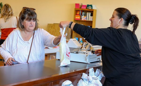 Rachel Maryan, a Reno’s employee, hands Karen Golab a bag with her purchase over the counter. Maryan is one of Reno’s first employees at their new St. Charles location.