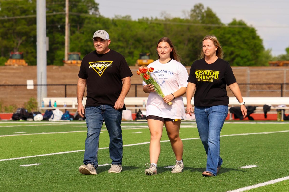 Senior Ella VarVera walks out with her parents during Girls Lacrosse's Senior Night. Senior Night was on May 2 against Oakville High School.