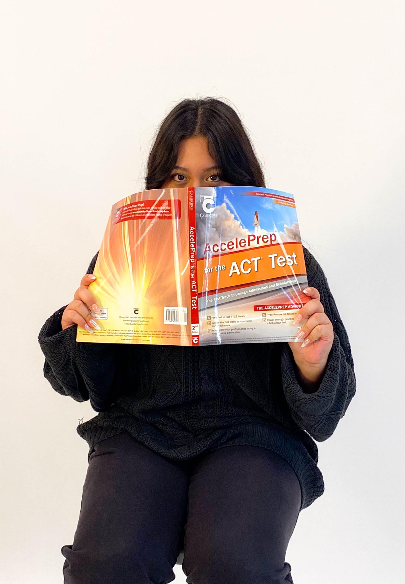Senior Melissa Guerrero-Bernal holds up an ACT practice booklet.