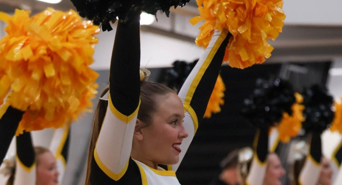 Reece Arehart cheers with the varsity cheer team during a boys basketball game. 