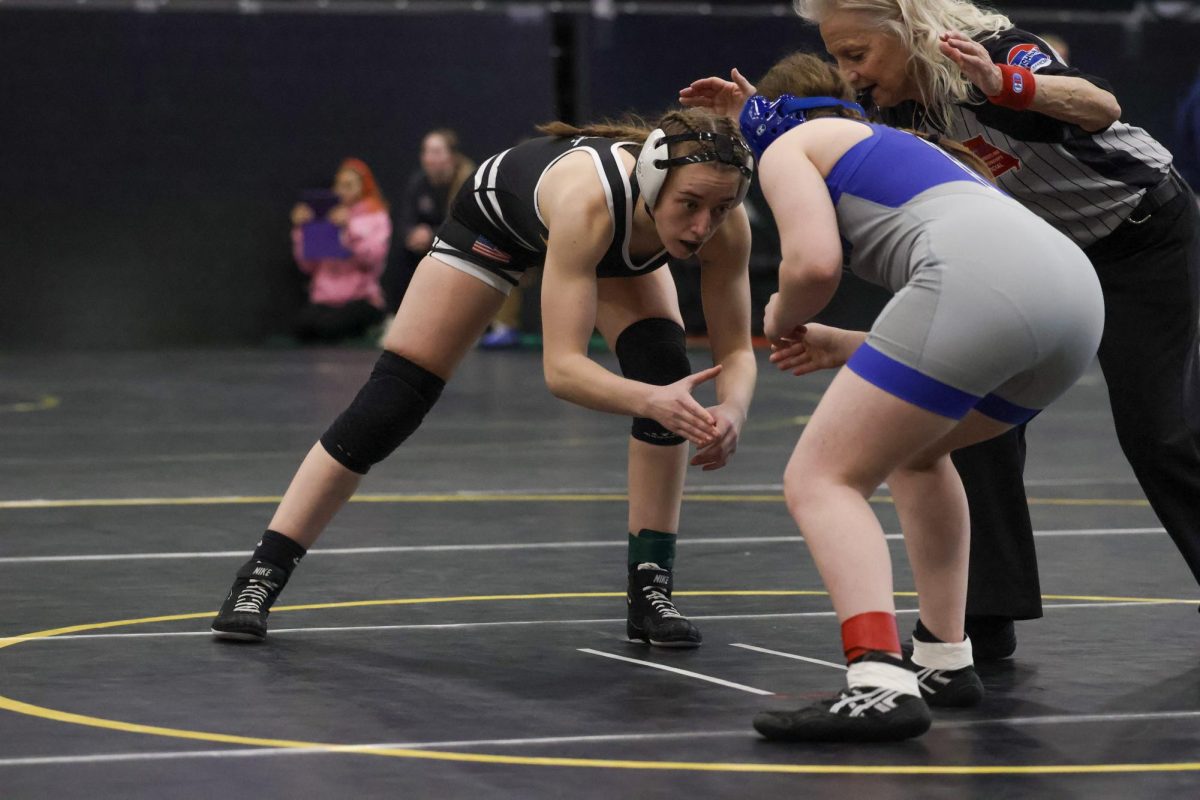 Senior Aubrey Peterson begins to shake hands with her opposing wrestler in the Varsity girls district tournament.