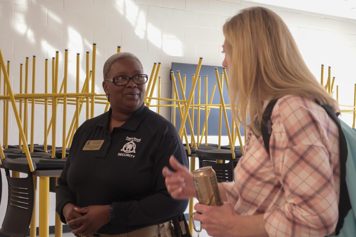 Rodessa Scoggins speaks with a para in the hallway during passing period. 