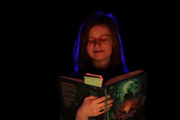 Junior Ryan Nuekomm reads from her campaign book, “The Crooked Moon" where she takes inspiration for her D&D Campaign "The Horrific Anti-Heroes."