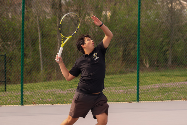 Tennis player goes up to serve during a match